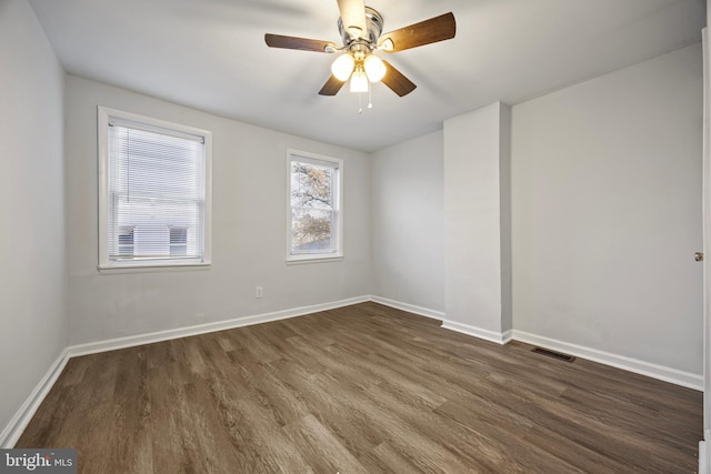 empty room with dark hardwood / wood-style flooring and ceiling fan