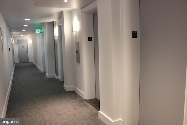 hallway featuring dark carpet