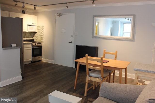 dining room with crown molding, rail lighting, and dark wood-type flooring