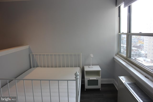 bedroom featuring dark hardwood / wood-style flooring and multiple windows