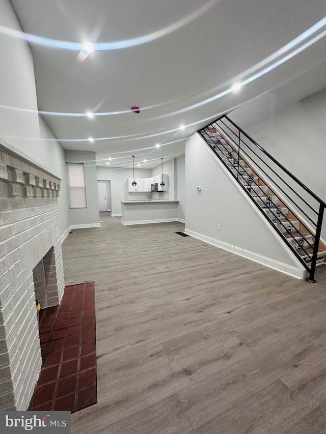 unfurnished living room featuring a fireplace and hardwood / wood-style flooring