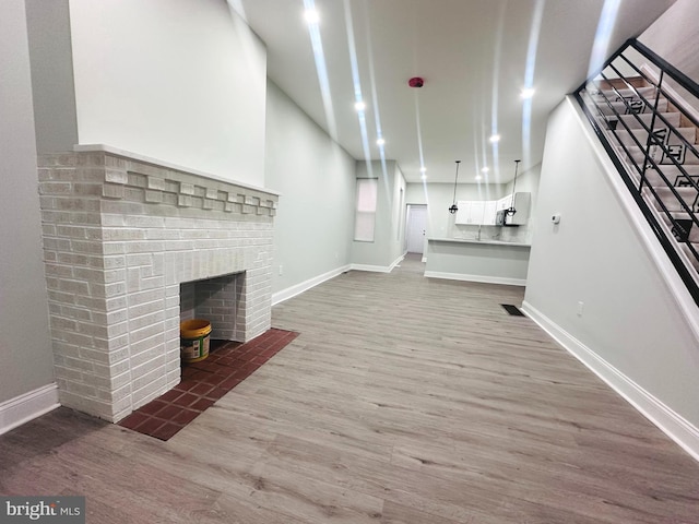 unfurnished living room featuring wood-type flooring and a fireplace