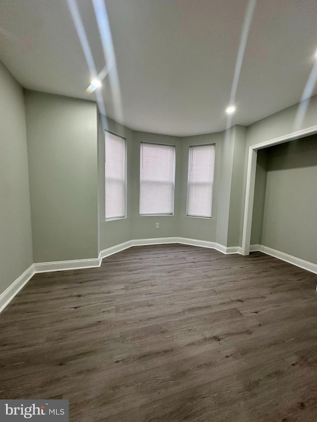 spare room featuring dark wood-type flooring