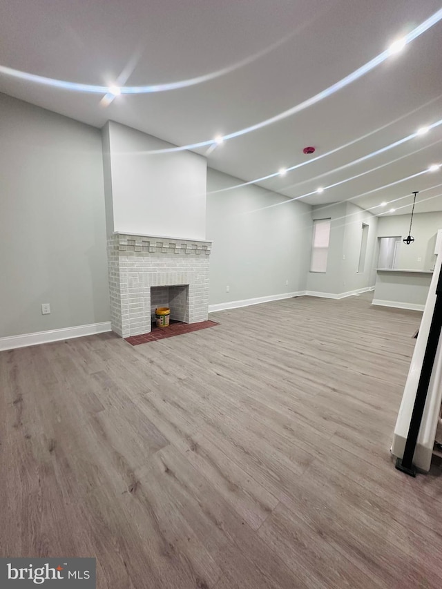 basement with a fireplace and light hardwood / wood-style flooring