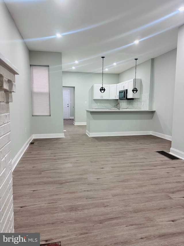 unfurnished living room with light hardwood / wood-style flooring and sink