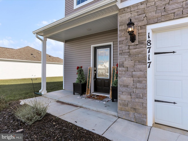 property entrance featuring covered porch and a yard