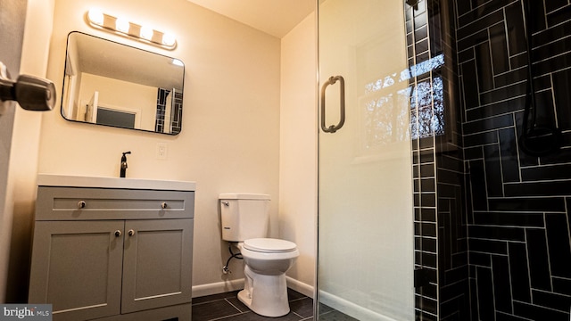 bathroom featuring toilet, a shower with door, vanity, and tile patterned floors