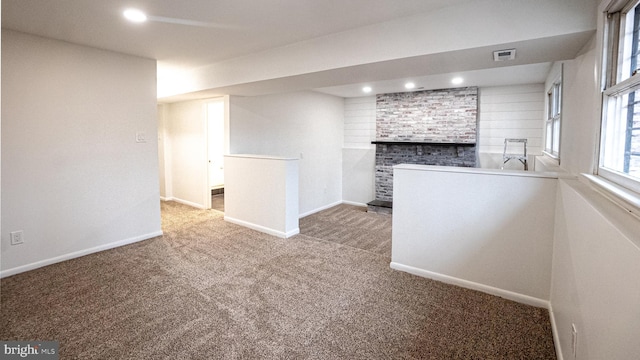 interior space featuring a brick fireplace and carpet