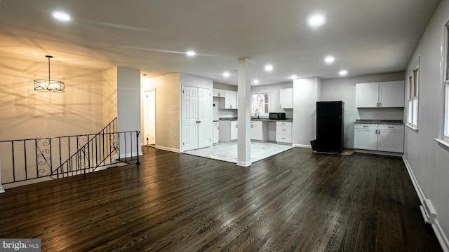 unfurnished living room with dark hardwood / wood-style flooring and sink