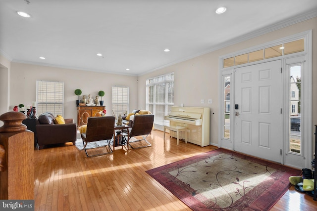 foyer entrance with crown molding and light wood-type flooring