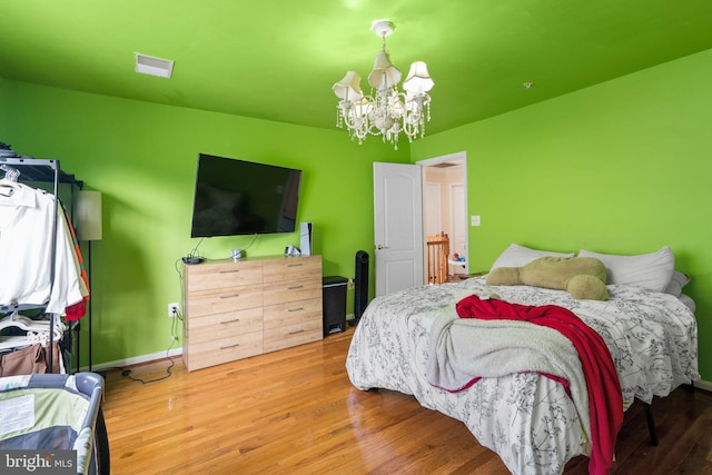 bedroom featuring wood-type flooring and a chandelier