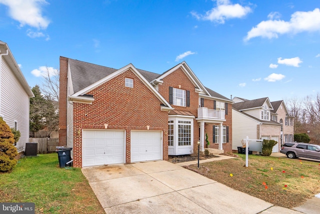 front of property featuring central air condition unit, a balcony, a front yard, and a garage