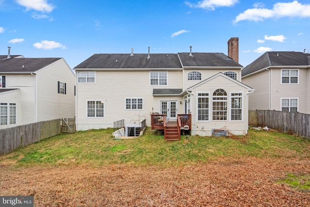 back of house featuring a lawn and a wooden deck