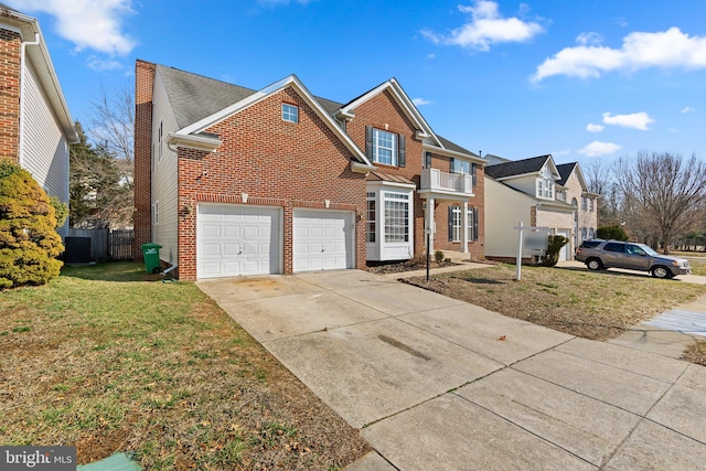 traditional home with brick siding, fence, a balcony, driveway, and a front lawn