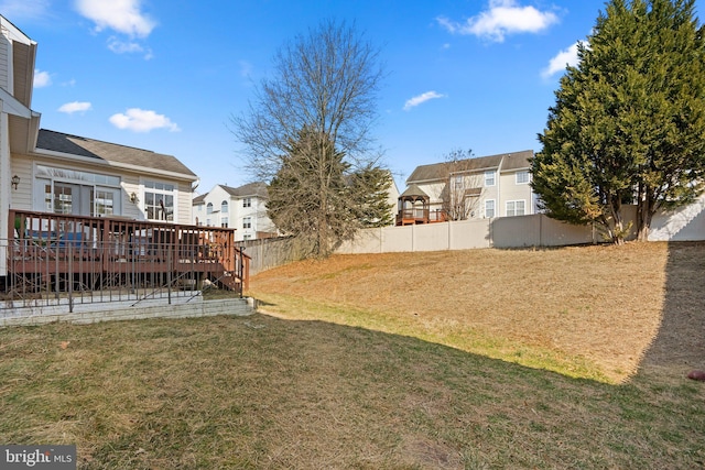 view of yard with a residential view, a fenced backyard, and a wooden deck