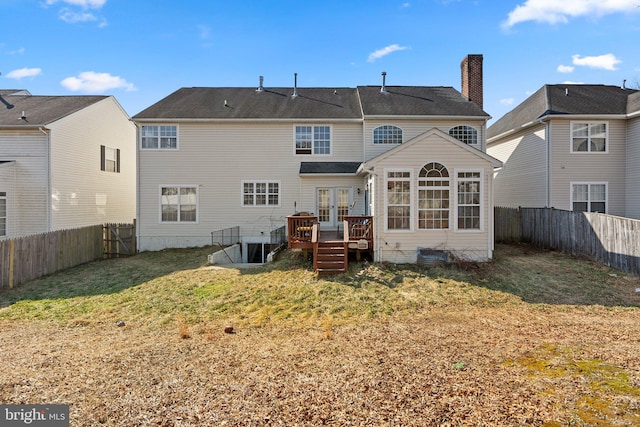 back of property with french doors, a fenced backyard, a yard, and a wooden deck