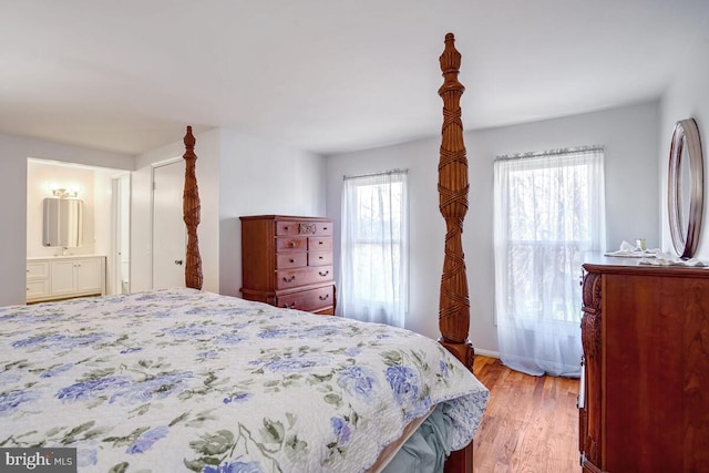 bedroom with light hardwood / wood-style floors and ensuite bathroom