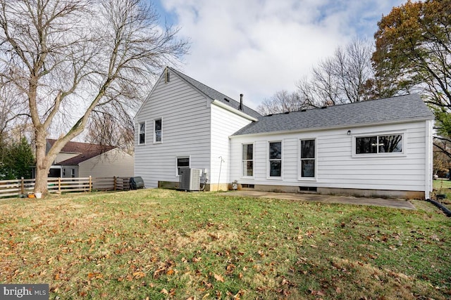 back of house with a yard and central air condition unit