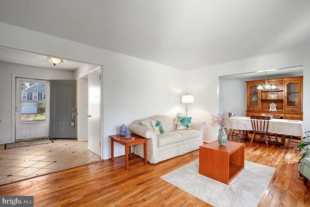 living room featuring light hardwood / wood-style floors and a notable chandelier