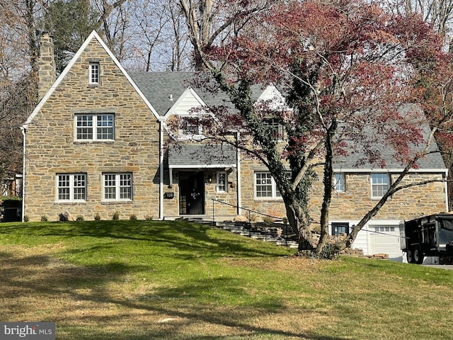 tudor home featuring a front lawn