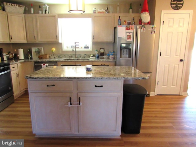 kitchen featuring light hardwood / wood-style floors, a center island, stainless steel appliances, and sink