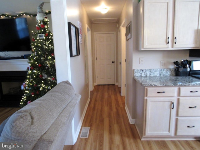 kitchen featuring light stone countertops and light wood-type flooring