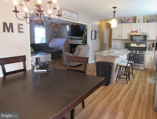 dining area with a notable chandelier and light hardwood / wood-style flooring