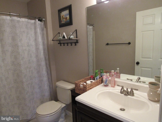 bathroom featuring vanity, toilet, and curtained shower