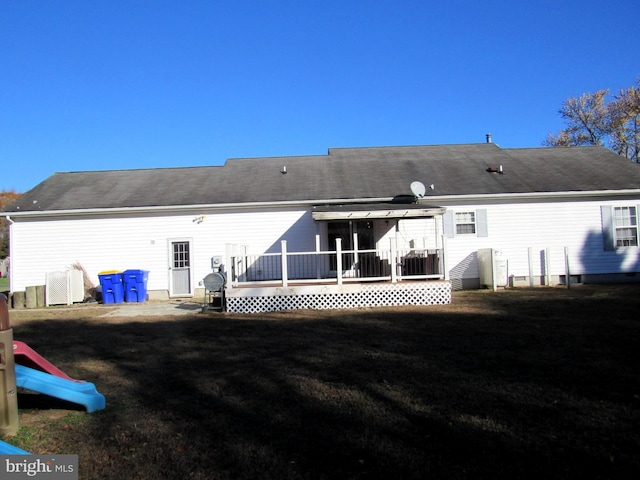 back of house featuring a deck, cooling unit, and a lawn