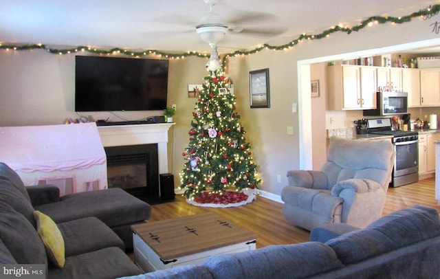 living room with ceiling fan and light hardwood / wood-style flooring