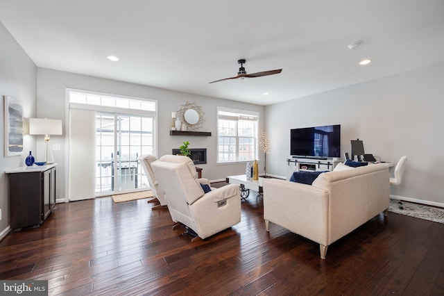 living room featuring dark wood-type flooring and ceiling fan