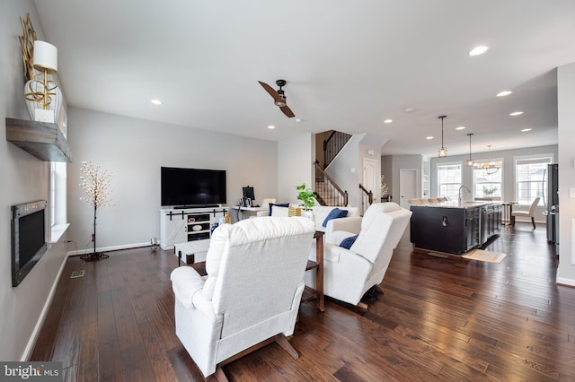 living room featuring ceiling fan, dark wood-type flooring, and sink