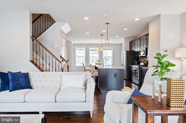 living room featuring dark wood-type flooring and a chandelier