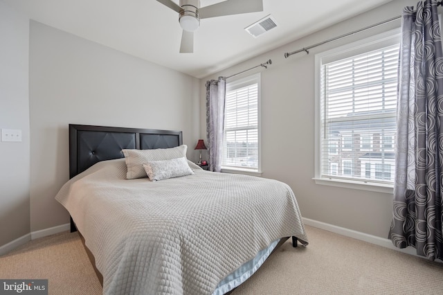 carpeted bedroom with multiple windows and ceiling fan