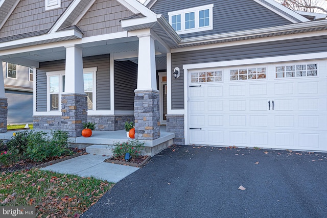 entrance to property featuring a porch and a garage