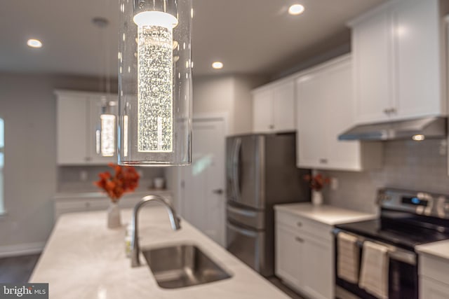 kitchen featuring stainless steel appliances, sink, exhaust hood, pendant lighting, and white cabinets