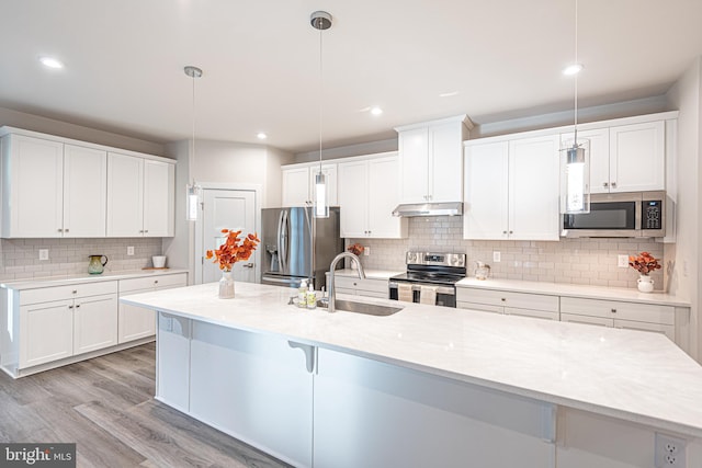 kitchen with pendant lighting, white cabinetry, sink, and appliances with stainless steel finishes