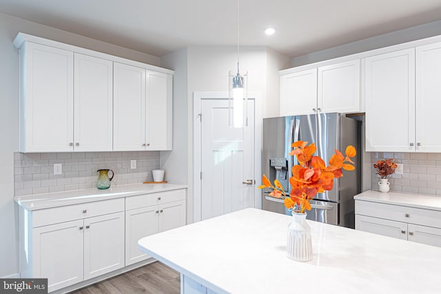 kitchen featuring white cabinets and stainless steel refrigerator with ice dispenser