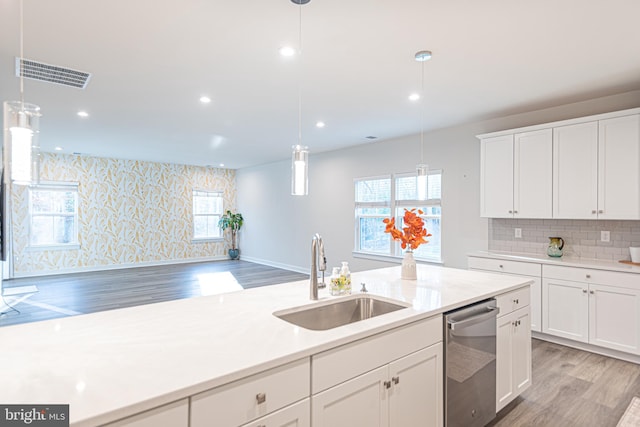 kitchen featuring stainless steel dishwasher, decorative light fixtures, white cabinetry, and sink