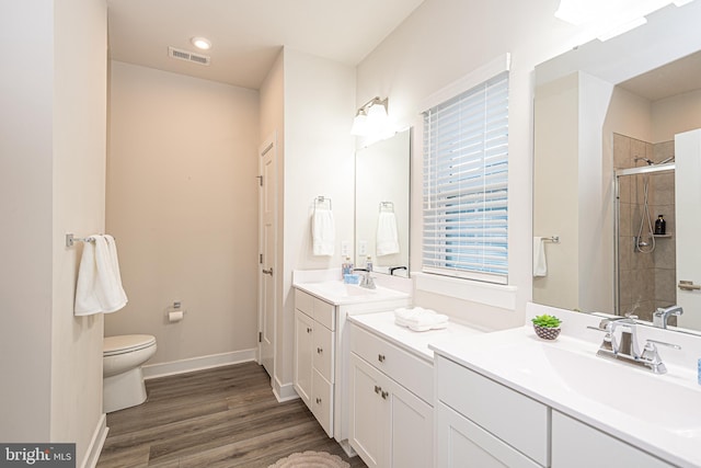 bathroom featuring walk in shower, hardwood / wood-style floors, vanity, and toilet