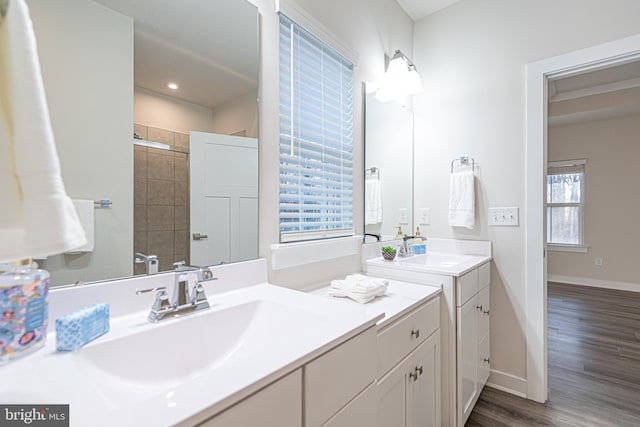 bathroom featuring hardwood / wood-style floors, vanity, a shower with shower door, and a wealth of natural light