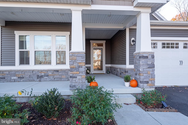 entrance to property featuring covered porch and a garage