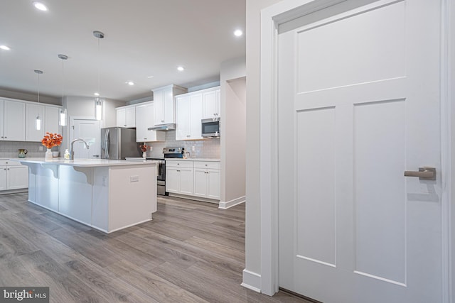 kitchen with white cabinets, light wood-type flooring, and stainless steel appliances