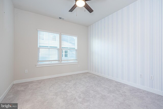 spare room featuring ceiling fan and light carpet