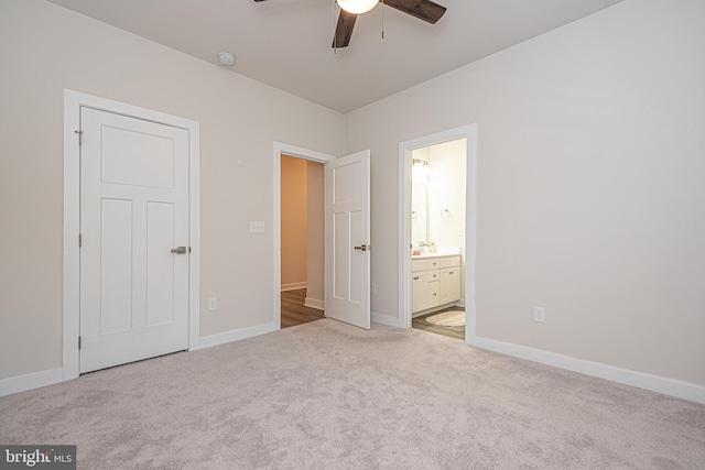 unfurnished bedroom with ensuite bathroom, ceiling fan, and light carpet