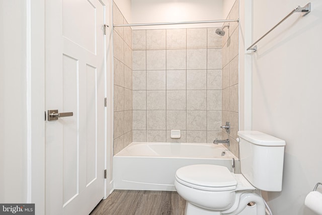 bathroom featuring hardwood / wood-style floors, toilet, and tiled shower / bath