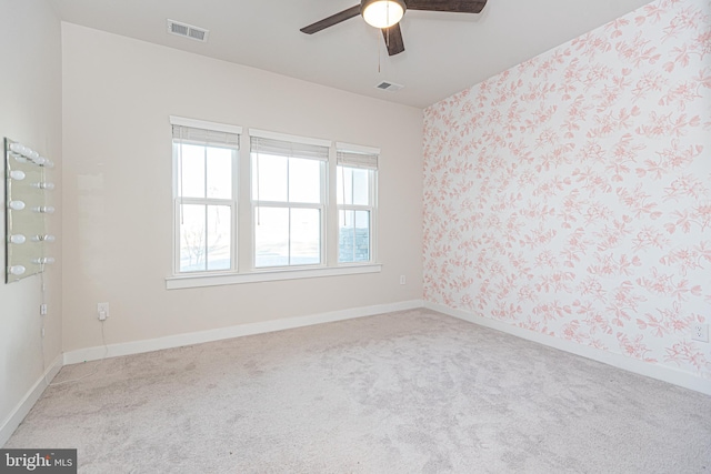 carpeted empty room featuring ceiling fan