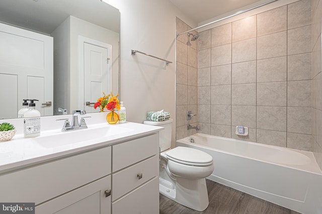 full bathroom featuring toilet, vanity, tiled shower / bath combo, and hardwood / wood-style flooring