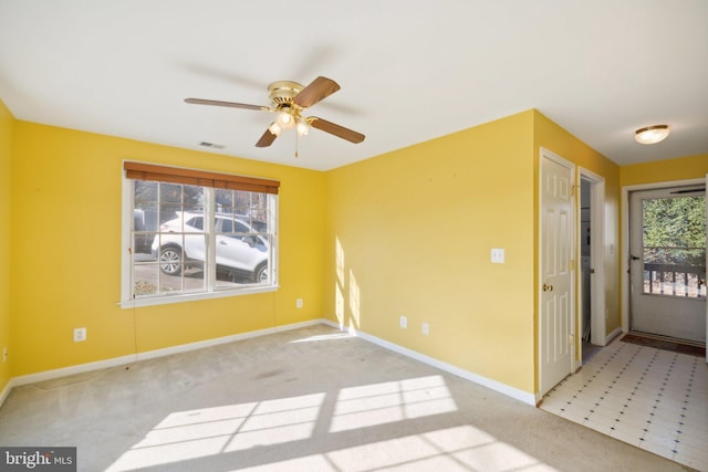 carpeted spare room featuring ceiling fan and a healthy amount of sunlight