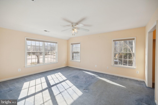 spare room with ceiling fan and dark carpet